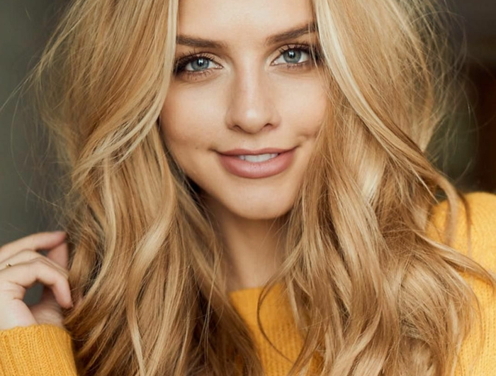 jeune femme blonde pull jaune maquillage nude coloration blonde cheveux longs messy raie symétrique