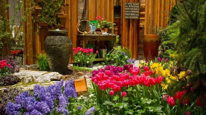 massif fleurs, jacinthes et tulipes, grand vase décoratif, arbustes et fleurs arrangés ensemble 