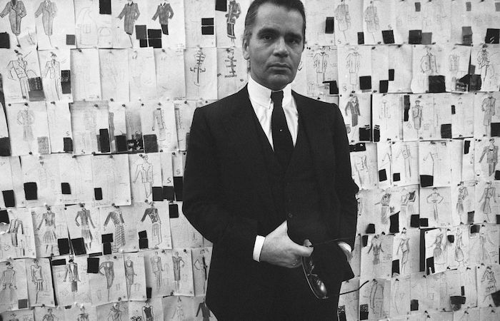 Photo de Karl Lagerfeld devant ses dessins et croquis dans les ateliers de Chanel dans les années 80