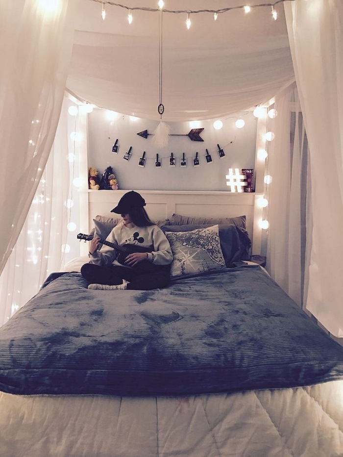 Quelle deco chambre ado choisir, chambre tumblr avec beaucoup de guirlandes lumineuses, fille qui joue à la guitare assise sur son lit cozy