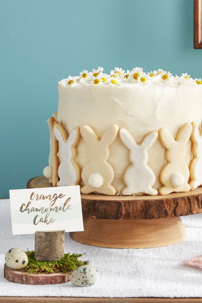 gâteau sur le thème de pâques orange et camomille, recouvert de glaçage crème beurre décoré de petits sables au glaçage blanc en forme de lapins