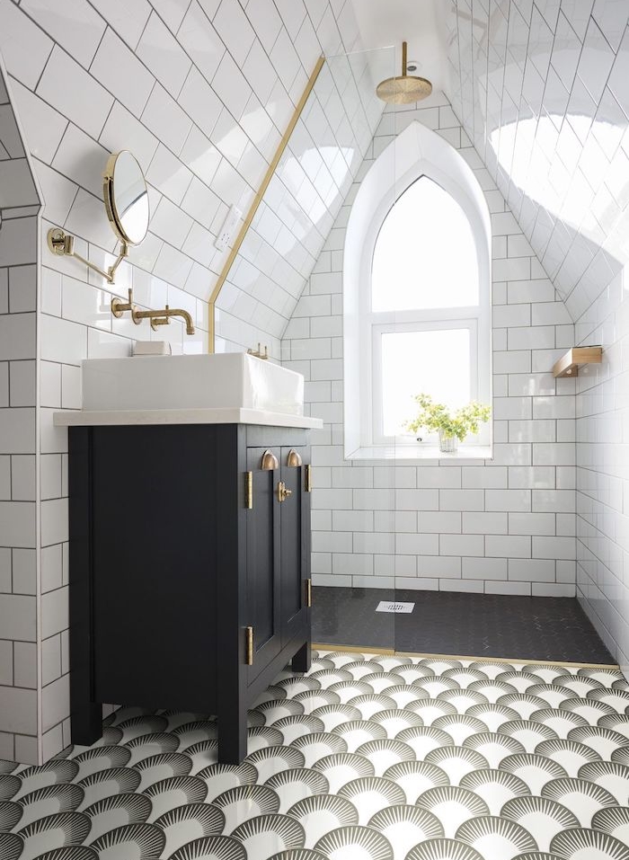 salle de bain mansardée avec douche en laiton, carrelage noir et carrelage décoratif, meuble salle de bain noir avec vasque à poser blanche, murs en carrelage metro blanc