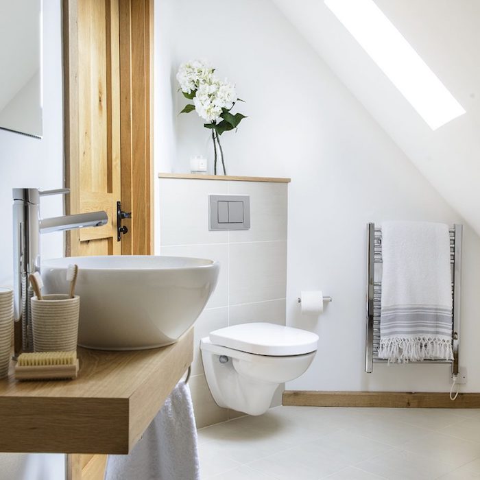 salle de bain en carrelage gris clair, murs blancs, vasque sur planche bois flottante, wc suspendu, salle de bain moderne