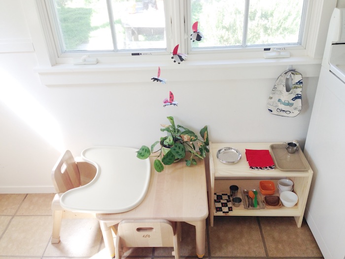meuble vaisselle enfant avec chaise et table bois clair sur un carrelage marron dans la cuisine, murs blancs, espace à manger enfant