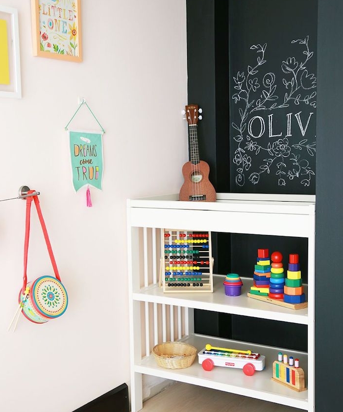 mur en peinture ardoise pour que l enfant puisse dessiner dessus, meuble rangement bas pour jouets, mur blanc décoré de dessins et decorations enfant