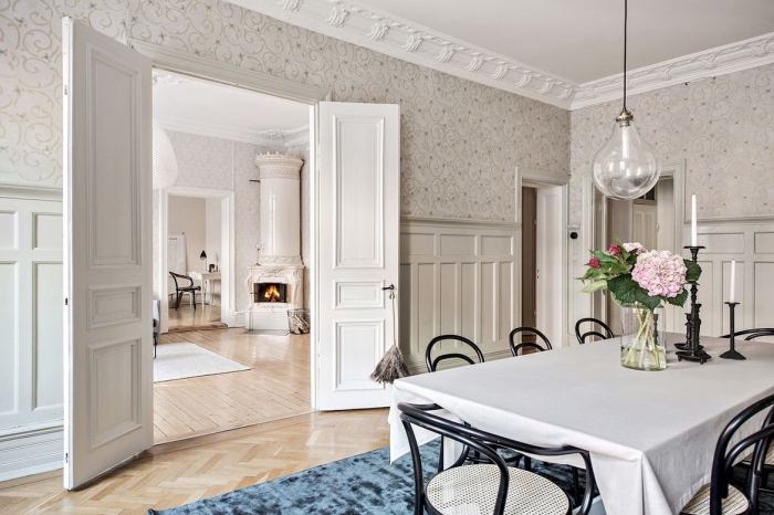 une salle à manger d'esprit vintage scandinave, habillage mur intérieur bois et papier peint