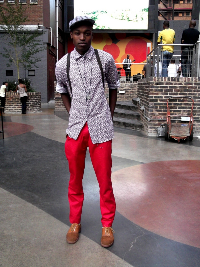 vetement africain homme, pantalon rouge, chemise bleu claire aux motifs graphiques, casquette bleu clair, chaussures marron