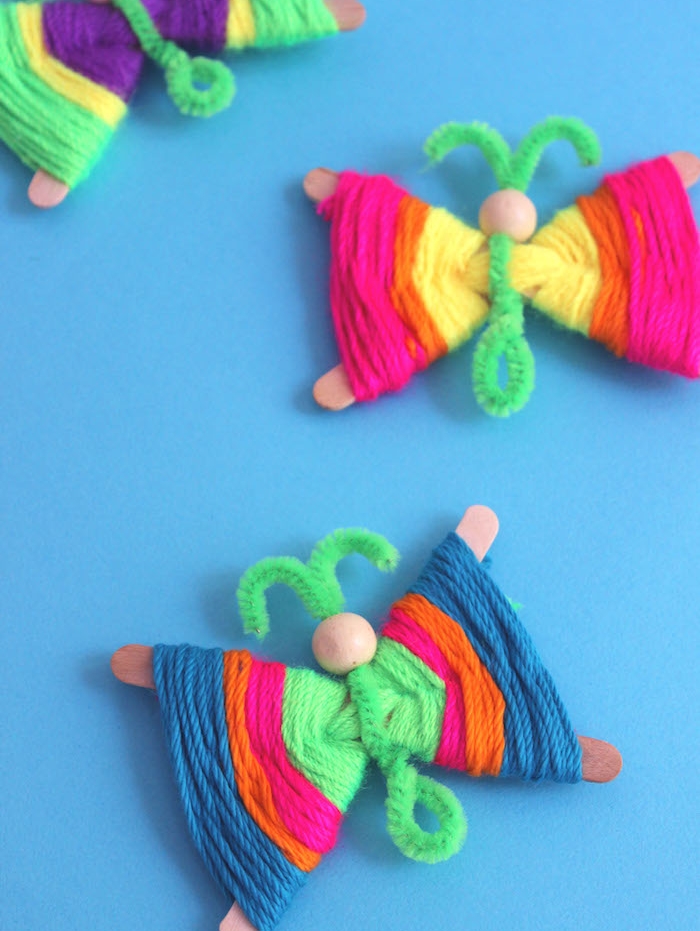 papillons de batonnets de glace décorées de fils de laine et corps en cure pipe et tete en perle de bois, bricolage enfant