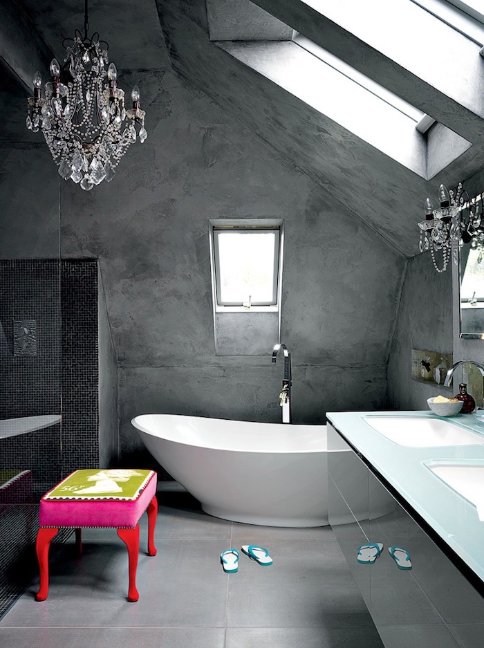 peinture à effet salle de bain à effet béton gris, baignoire blanche, tabouret rose et rouge, sol carrelage gris, lustres élégantes, meuble salle de bain avec plan de travail en verre