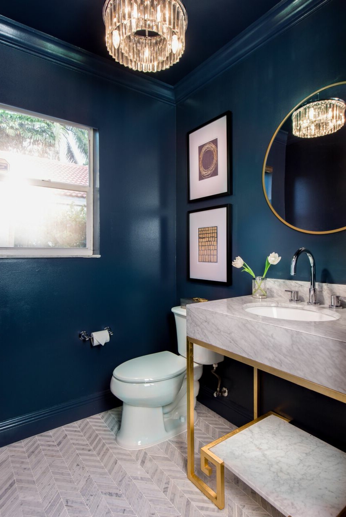 plafonnier cristal dans la toilette, vasque gris clair, peinture murale bleue, wc design bleu et blanc, miroir ovale cadre or