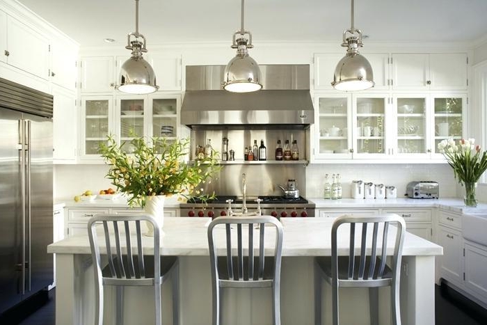 cuisine blanche, chaises grises, lampes chromées, réfrigérateur encastrable, armoires de cuisine vitrées