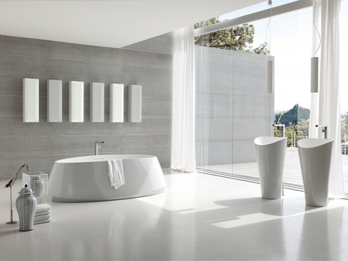 design lumineux dans une salle de bain spacieuse aux murs en gris clair aménagée avec baignoire autoportante