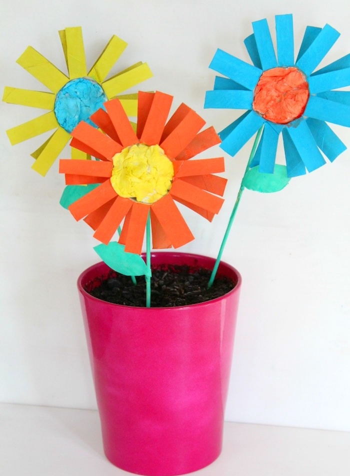 pot de fleurs artificielles en bandes de papier coloré et pot rose rempli de terre avec centre de papier de soie coloré