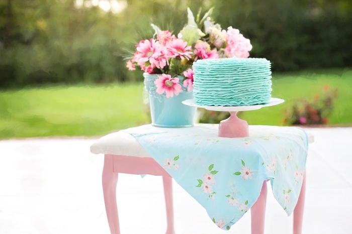 un joli ruffle cake bleu clair au glaçage en rubans pour une fête d'anniversaire sur thème champêtre
