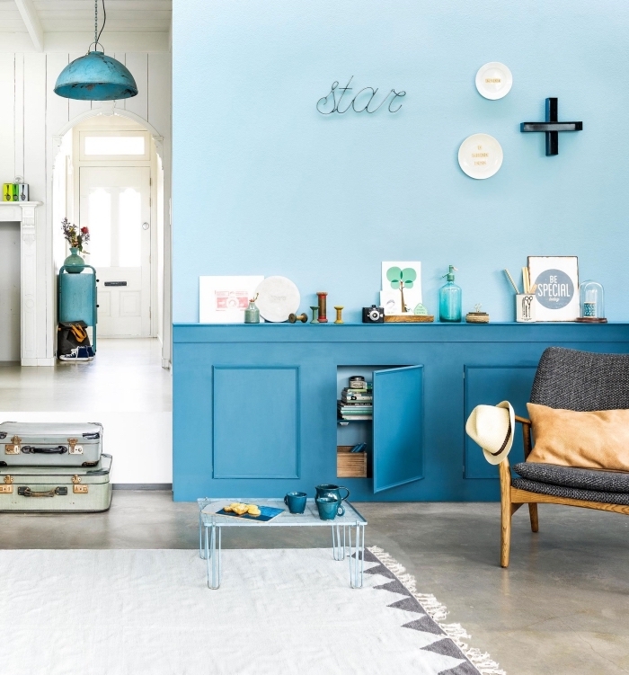 mur bicolore en nuances du bleu sarcelle qui illumine le salon de style vintage, soubassement en avec espace rangement intégré