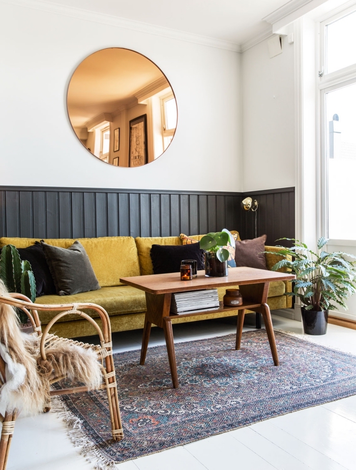du lambris noir en soubassement qui délimite l'espace dédié au canapé dans un salon vintage scandinave, peinture lambris tendance