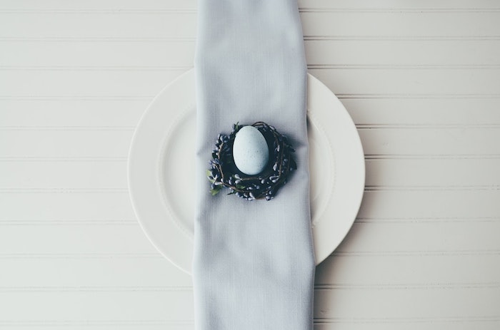 Table comment décorer pour les paques, bleu serviette et petit couronne de fleurs pour entourer l'oeuf bleu claire