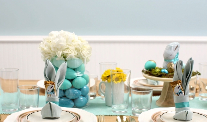 une belle décoration de table de pâques aux nuances du vert d'eau, modèle de pliage serviette lapin avec pochette