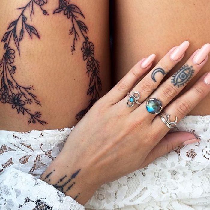 choix de tatouage bras femme au design simple et discret, tatouage lune et oeil réalisés sur l'annulaire et le majeur