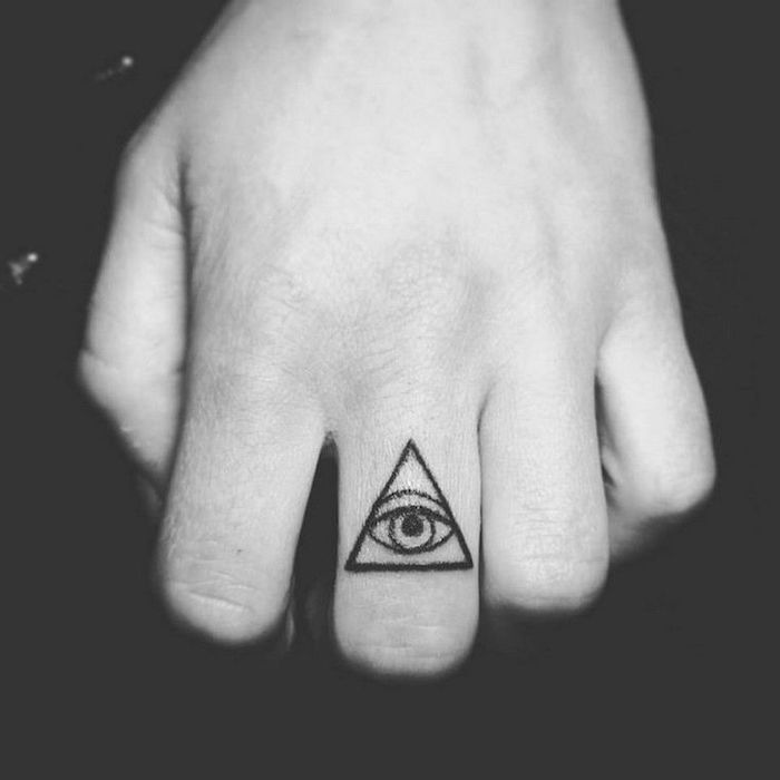 oeil dans un triangle d'aspect mystérieux tatoué sur le doigt majeur