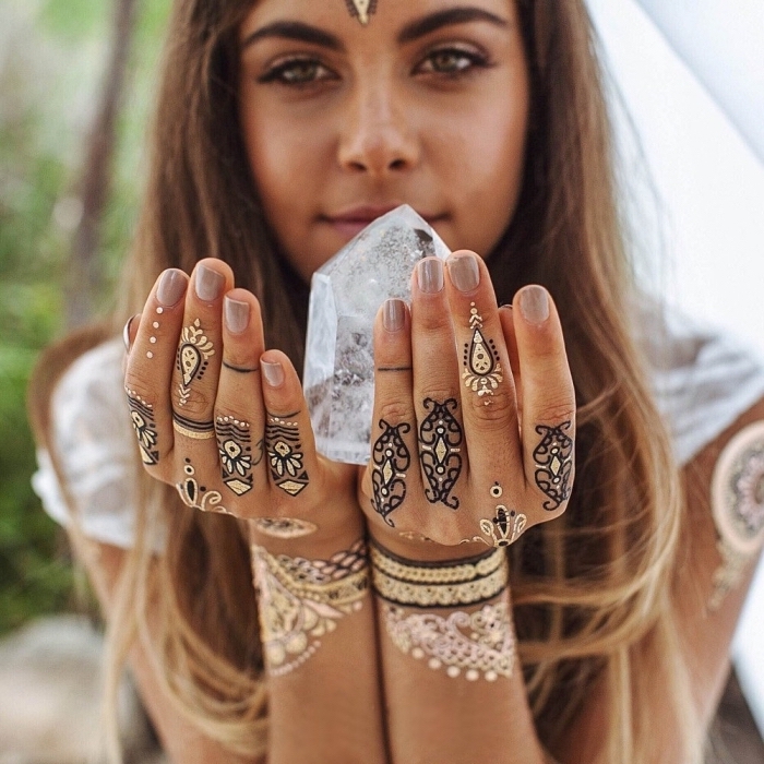 tatouages au henné noir dessinés sur les doigts des deux mains, tatouage bras au design oriental