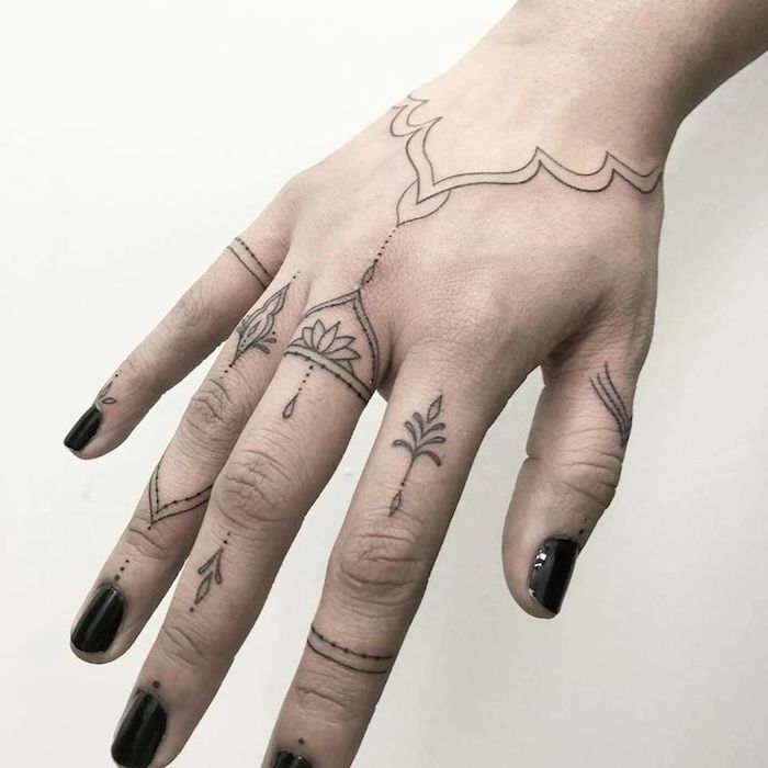 tatouage sur les doigts composé de dessins subtils aux motifs orientaux traditionnels qui s'assortissent avec le tatouage 