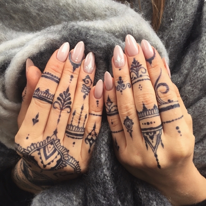 tatouage main au henné noir impressionnant, motifs au henné sur les doigts de la main aux design orientaux et floraux