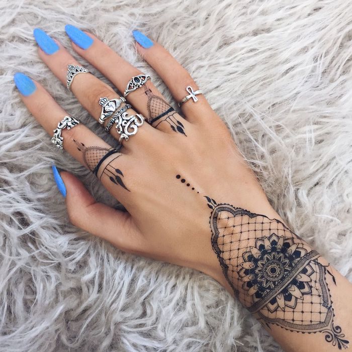 tatouage main à l'esthétisme oriental, tatouage au poignet représentant un mandala à effet dentelle, tatouage au henné sur l'annulaire et l'auriculaire 