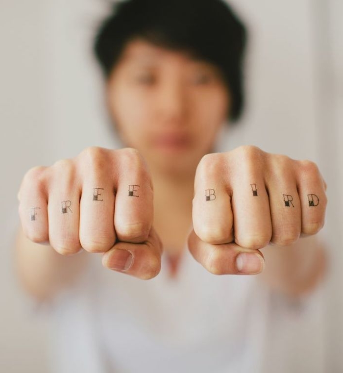 tatouage main femme pour transmettre un message personnel, tatouages de lettres sur les phalanges