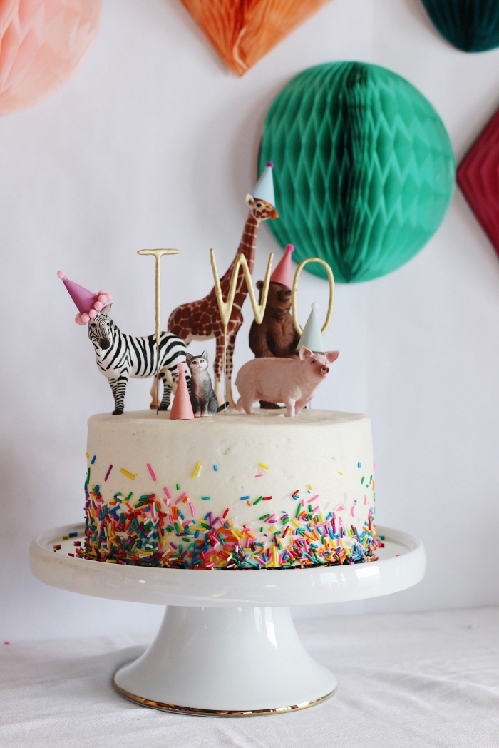theme anniversaire les animaux, gâteau d'anniversaire au glaçage de crème beurre et vermicelles en sucre décoré de figurines d'animaux 