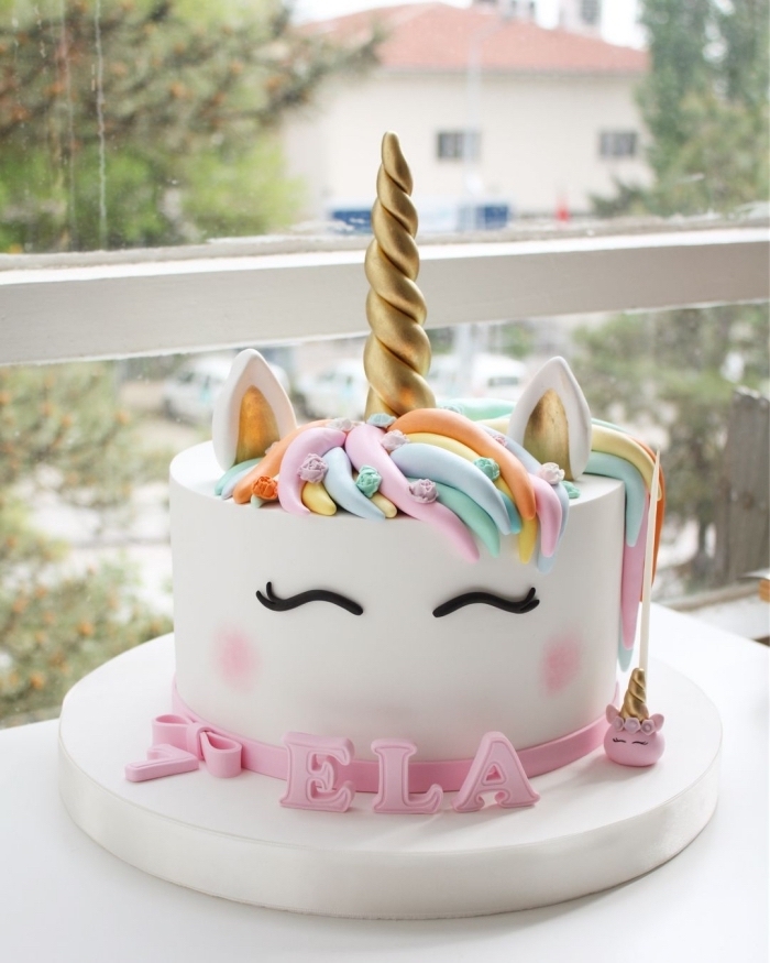joli gateau anniversaire fille en forme de tête de licorne aux petits décorations pastel en pâte à sucre 