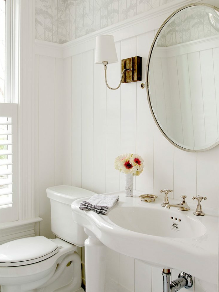 jolie décoration wc en blanc, miroir rond, vasque vintage à quatre pieds, lambris mural blanc, robinetterie rétro