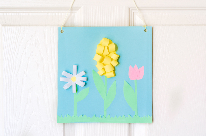 tableau decoratif de printemps en tulipe, jacinthe et marguerite, fleurs de papier sur fond bleu, activité manuelle primaire