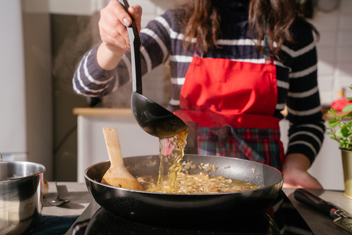 ajouter le bouillon de légumes au risotto et laisser cuire, recette risotto champignon et parmesan pour diner