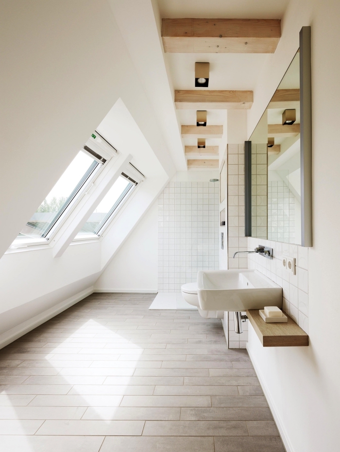 une salle de bains mansardée baignée de lumières grâce aux fenêtres de toit, une salle de bains au design épuré avec douce italienne 