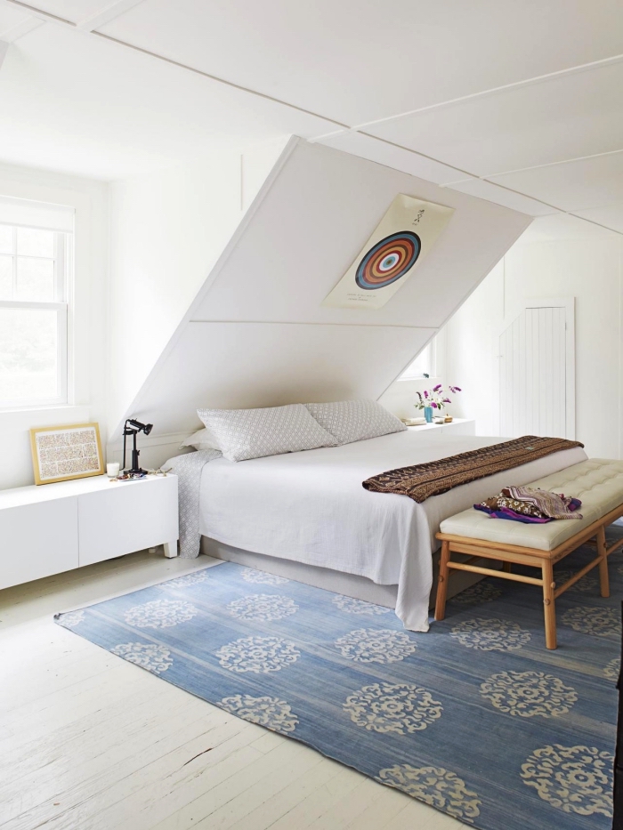 une chambre parentale blanche monochrome aménagée sous les combles avec un lit posé en sous-pente