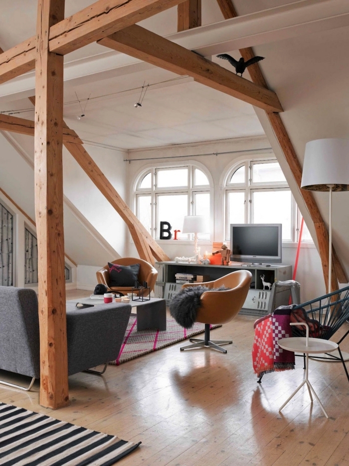 une chambre sous comble spacieuse de style vintage scandinave avec charpente apparente qui permet de structurer l'espace ouvert