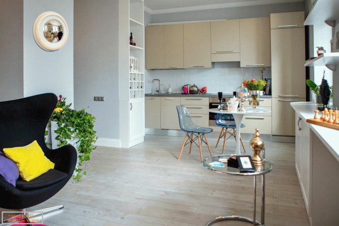 chaise oeuf noire, sol en bois clair, intérieur plan ouvert, kitchenette pour studio beige
