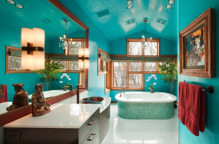 quelle peinture choisir pour salle de bain, exemple de salle de bain zen aux murs bleus avec décoration fleurs et statuette buddha