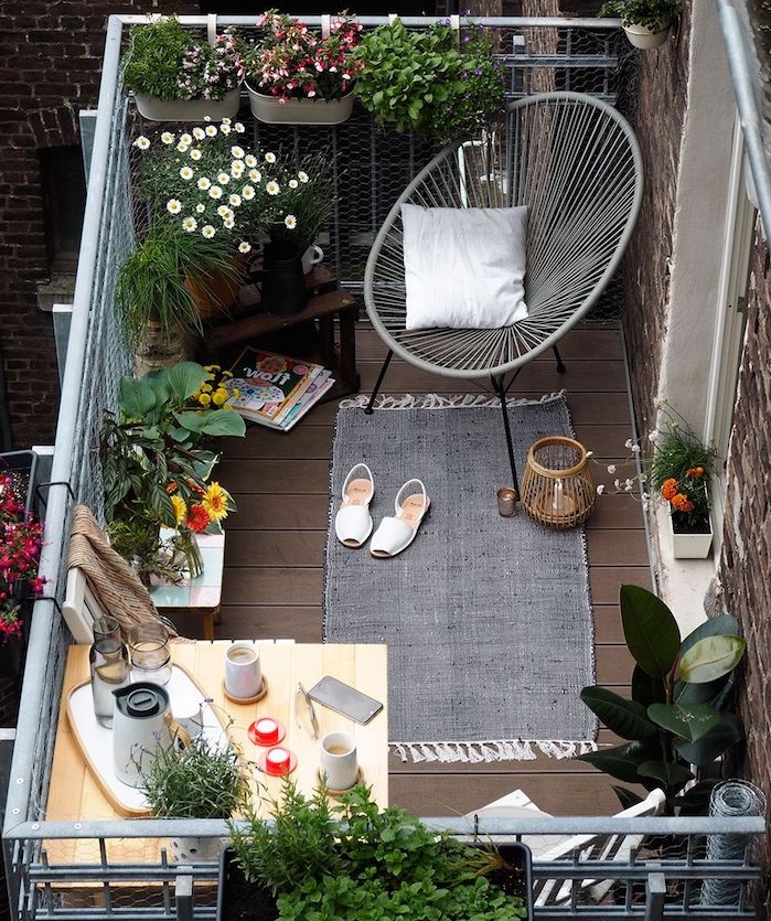 aménagement petit balcon fleuri avec chaise design, tapis gris, plantes de balcon fleuries, petite table balcon suspendue d angle