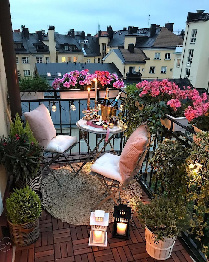 exemple deco balcon avec deux chaises pliantes et une table ronde pliante sur tapis rond tressé, pots et bacs à fleurs, créer une ambiance romantique
