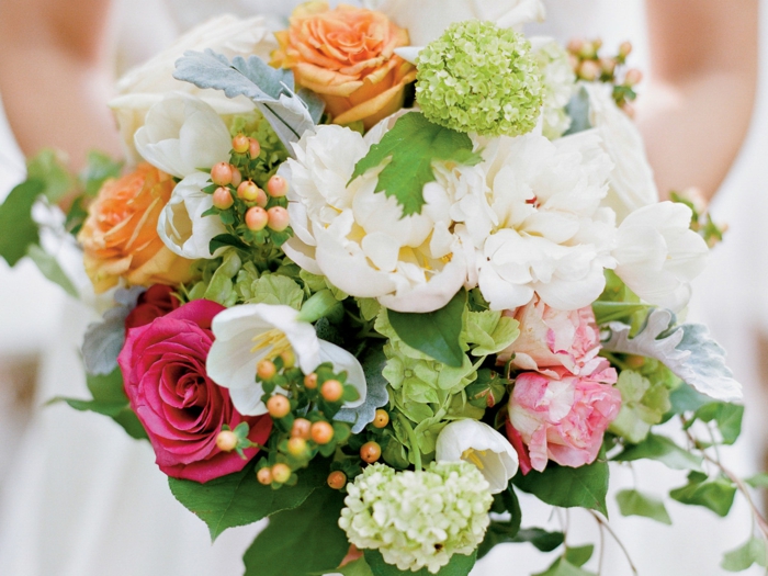 bouquet de mariée coloré avec pivoines et roses, baies jaunes, feuillage vert