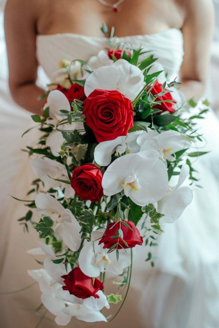 bouquet mariage cascade, callas blancs, roses rouges, feuillage vert, robe bustier blanche, collier