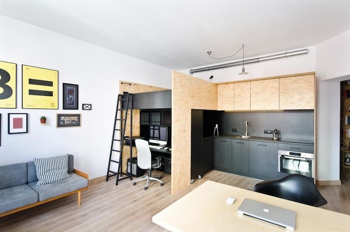 style scandinave de cuisine noire et bois avec bureau à côté et coin nuit chambre à coucher en dessus, ouverture sur salon design minimaliste