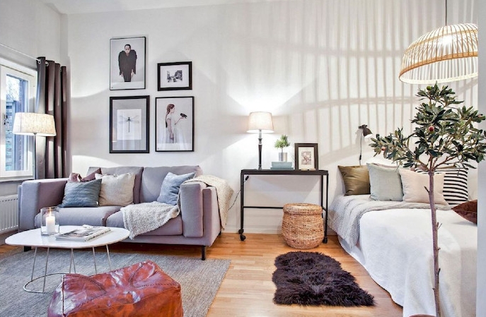aménagement studio 30 m2, chambre à coucher avec lit à côté d un petit salon scandinave nordique avec canapé, table basse scandinave, tapis gris, mur de cadres