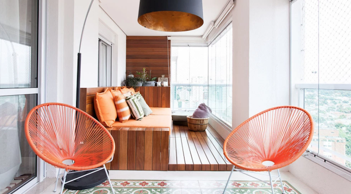 chaises de balcon metal orange et grand canapé de terrasse en bois, revetement sol bois et plantes rangées sur étagère, suspension design originale