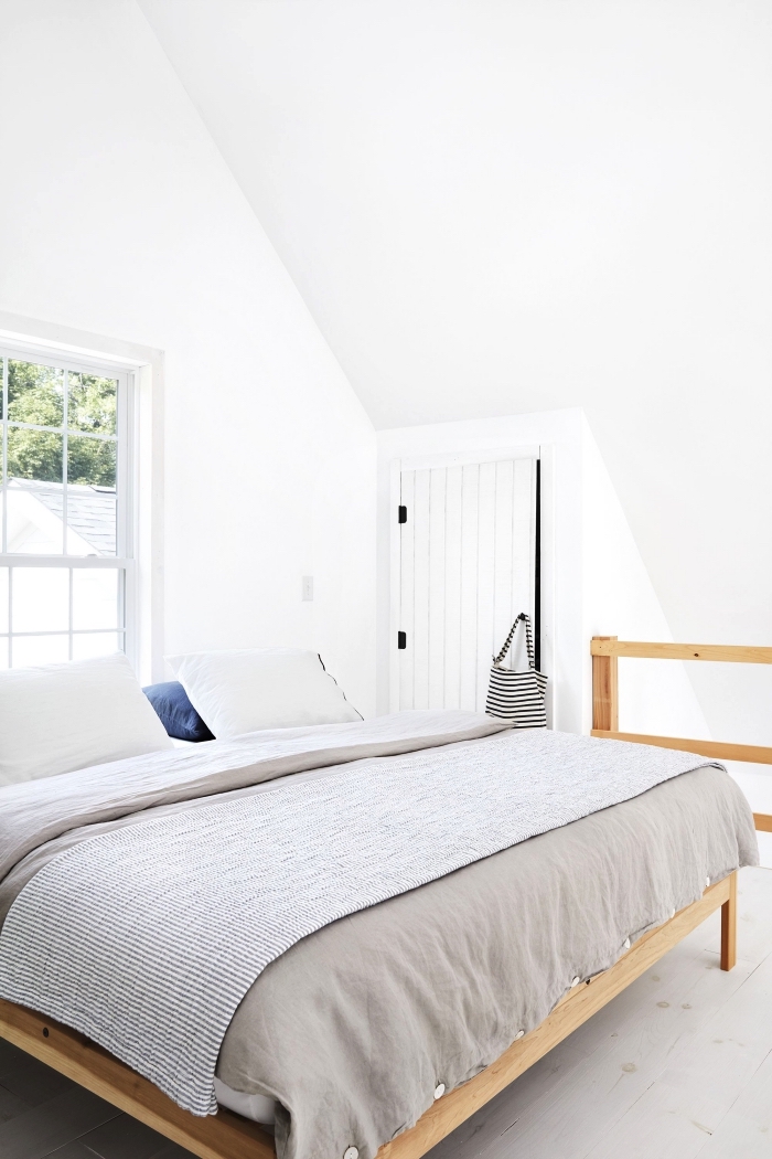 une chambre à coucher mansardée avec placard sous pente à porte en planches de bois peintes en blanc