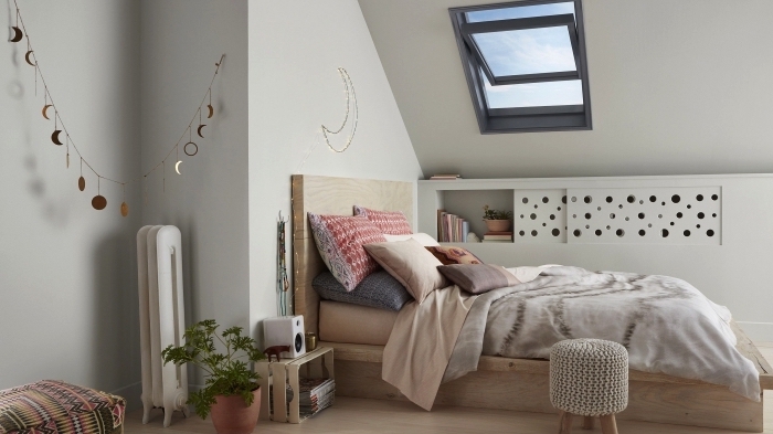 ambiance scandinave moderne dans une chambre à coucher mansardée avec une etagere sous pente à porte coulissante 
