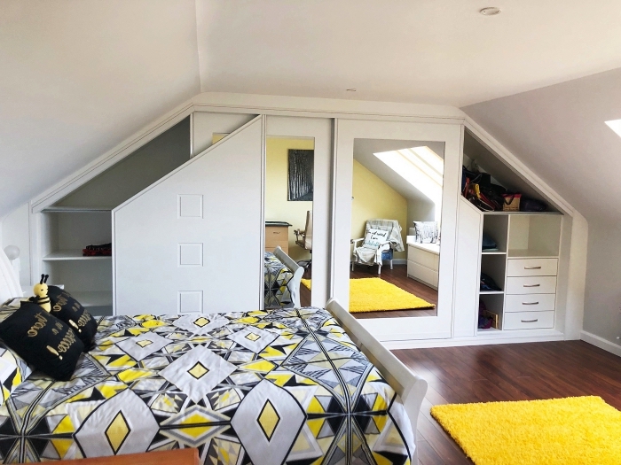 une chambre d'ado blanche mansardée aux accents en jaune et gris avec une armoire sous pente sur mesure