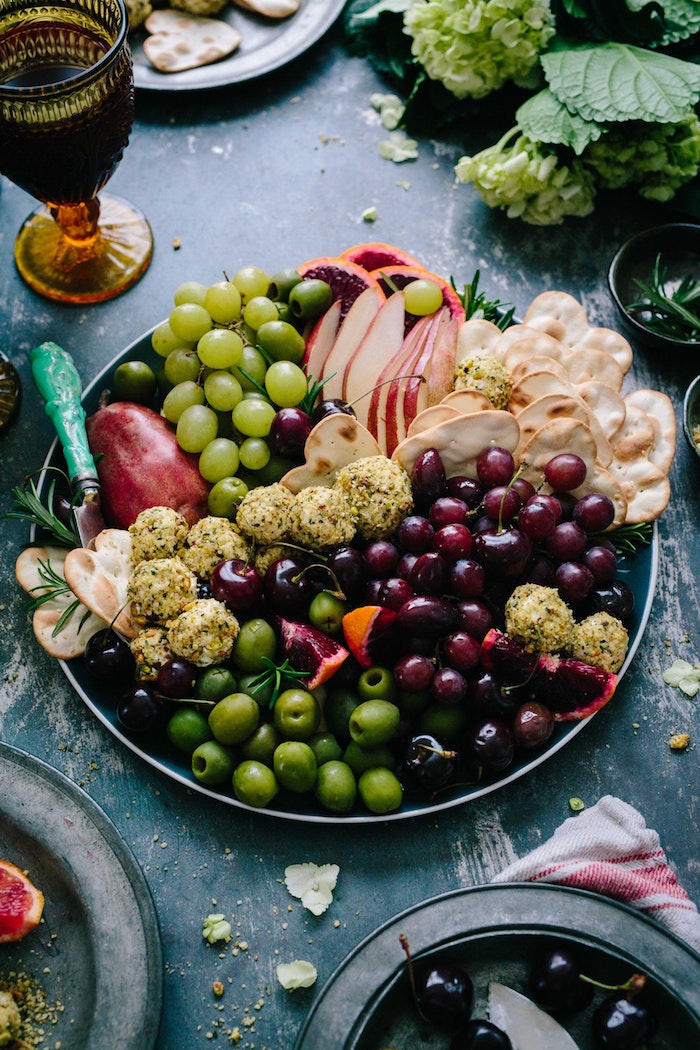Idée de repas de fete, entrée simple et raffinée avec olives, raisins, pomme fromages et crackers, inviter ses amis a un apero